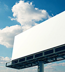 White billboard with blue sky and clouds in background